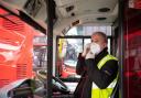 A bus driver adjusts a protective face mask at Camberwell bus depot in London, as the UK continues in lockdown to help curb the spread of the coronavirus. Photo: PA Wire