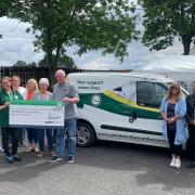 Representatives from the Great North Air Ambulance Service pick up the cheque for £1,175 which was fundraised by the Bellingham caravan owners