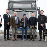 Tim Rivett of RTIG-INFORM, Ben Maxfield of Go North East, Cllr Glen Sanderson, Phillip Ward, Chris Theobald of Guide Dogs, Robert Johnson of DfT, and roads minister Guy Opperman with a bus which has audio and visual information technology installed