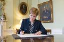Nicola Sturgeon signing her letter of resignation to the King on March 28, 2023