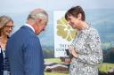 Heather Hancock, chair of trustees for The Royal Countryside Fund, presents King Charles III with the gold pin