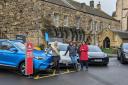 Zaria Greenhill, Cllr Suzanne Fairless-Aiken, and Cllr Ariane Baty stood next to some of the electric vehicles on show