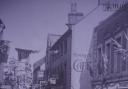 Fore Street, Hexham in the 1920s, as a military parade passes Robbs and The Sun Inn