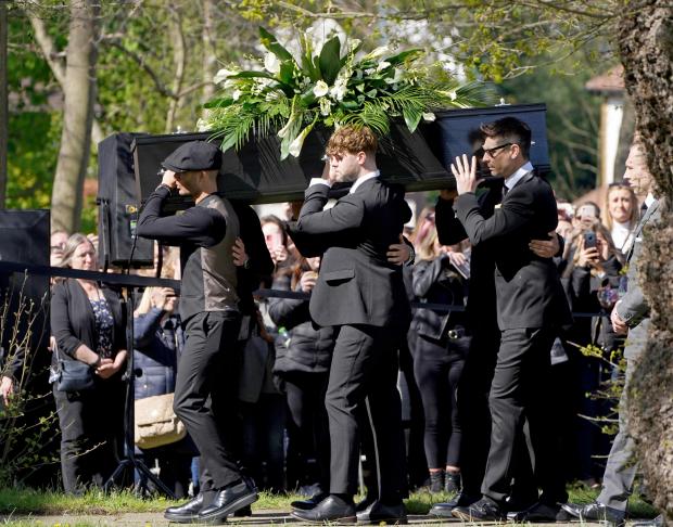 Hexham Courant: Max George (left) and Jay McGuiness of The Wanted (centre) carry the coffin at the funeral of their bandmate Tom Parker. (PA)