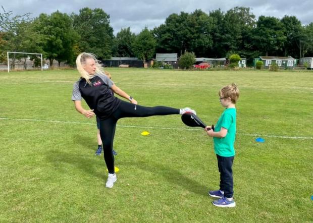 Hexham Courant: Simone practising taekwondo with a child taking part in the holiday camp