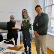 High school student Robbie Jarvis receiving the award from Lucia Fisher of Hexham Art Club, with art teacher Will Pym