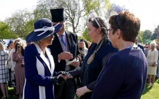 Queen Camilla shaking Niamh King's hand at the Buckingham Palace garden party
